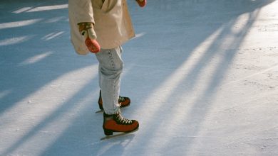 faceless fit woman skating on ice rink in daylight