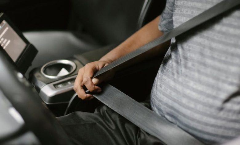 anonymous man fastening seat belt in vehicle