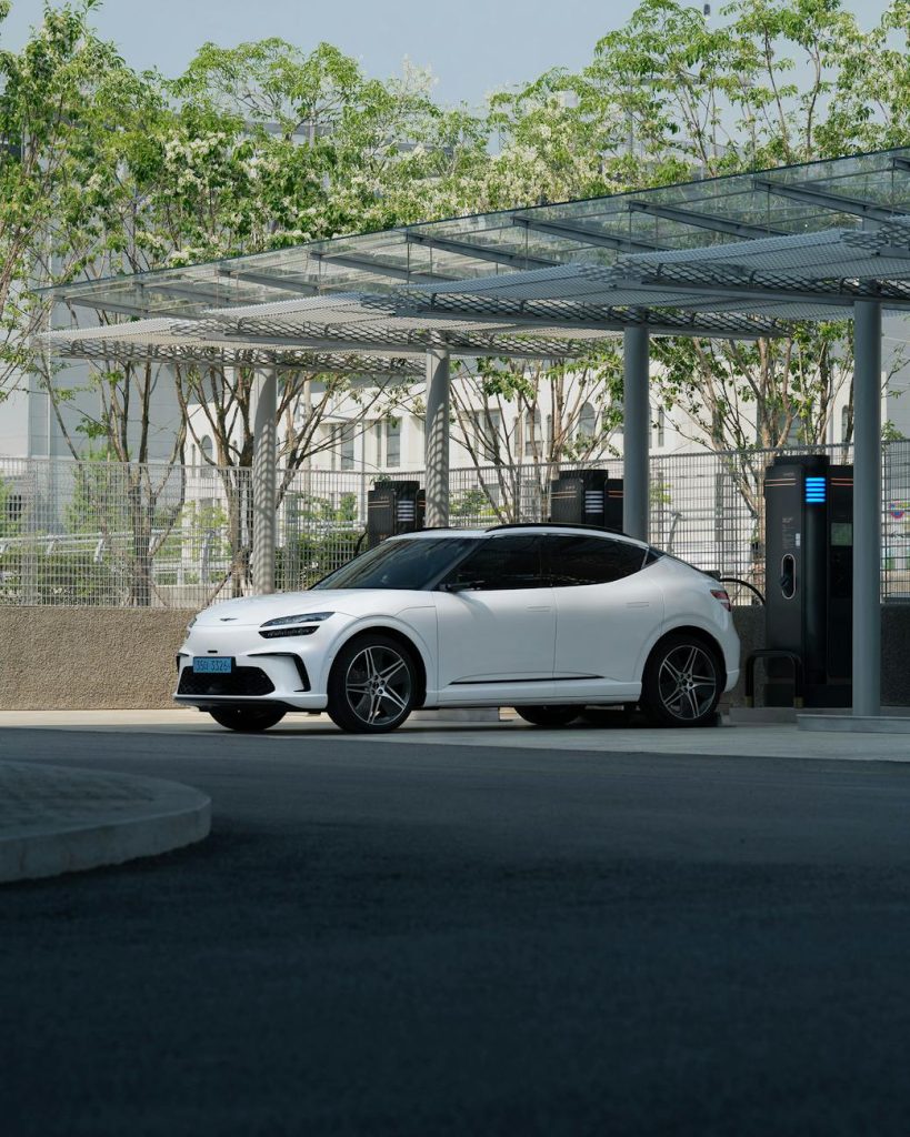 white electric suv charging at outdoor station